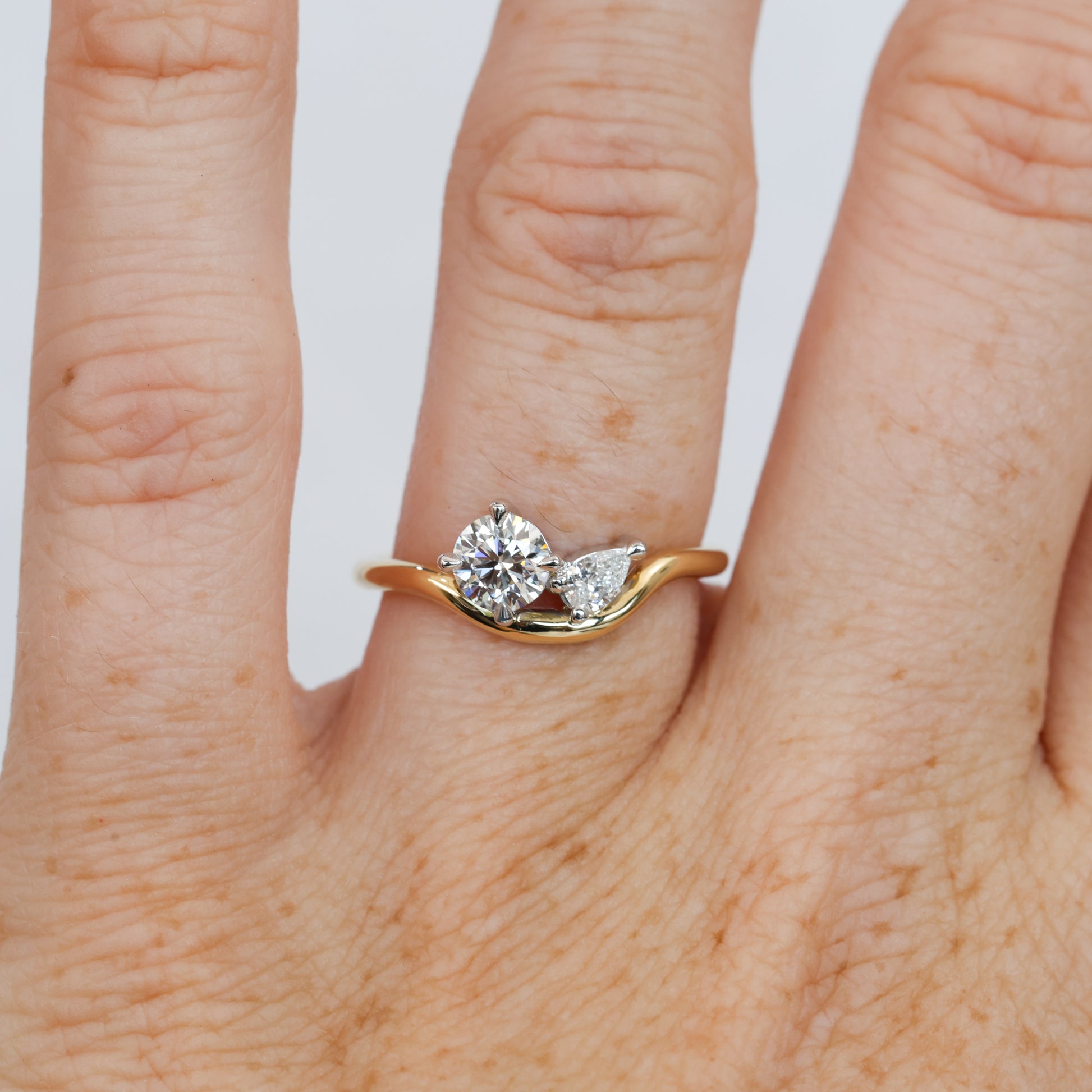 diamond toi et moi engagement ring on a curved band