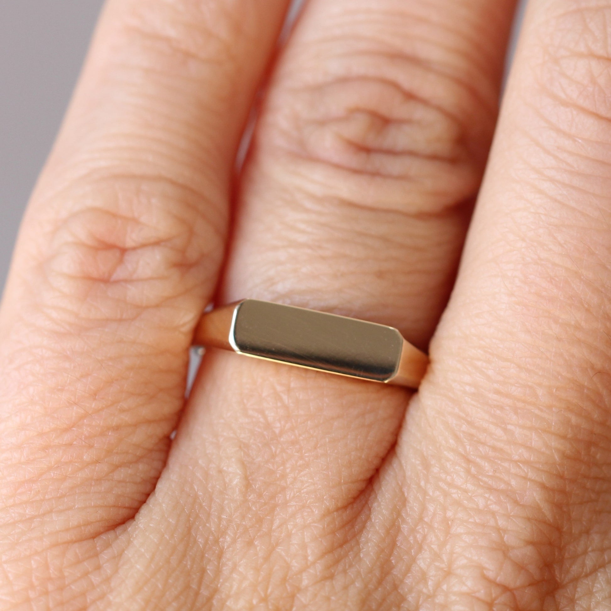 gold bar signet ring on hand 