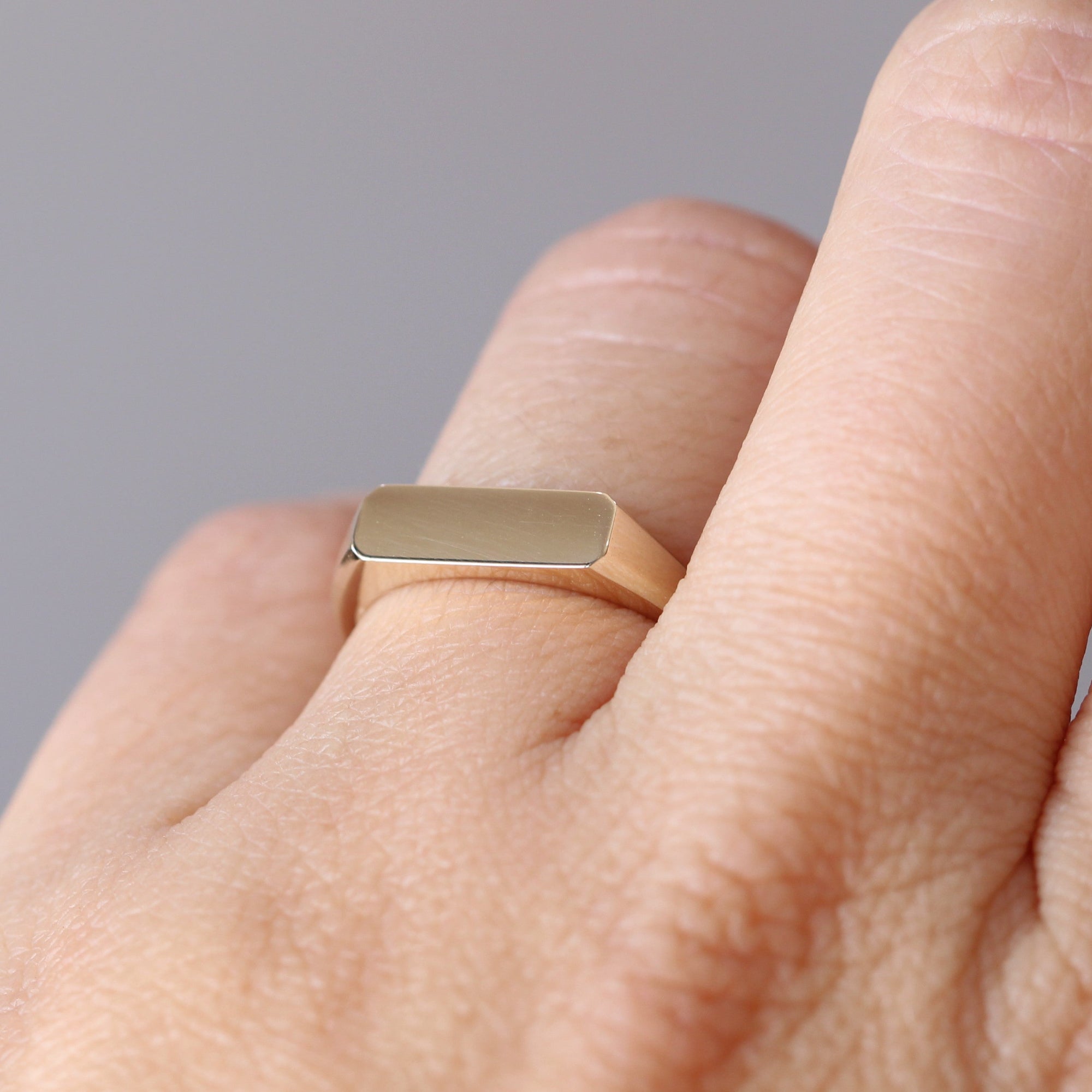 gold bar signet ring on hand