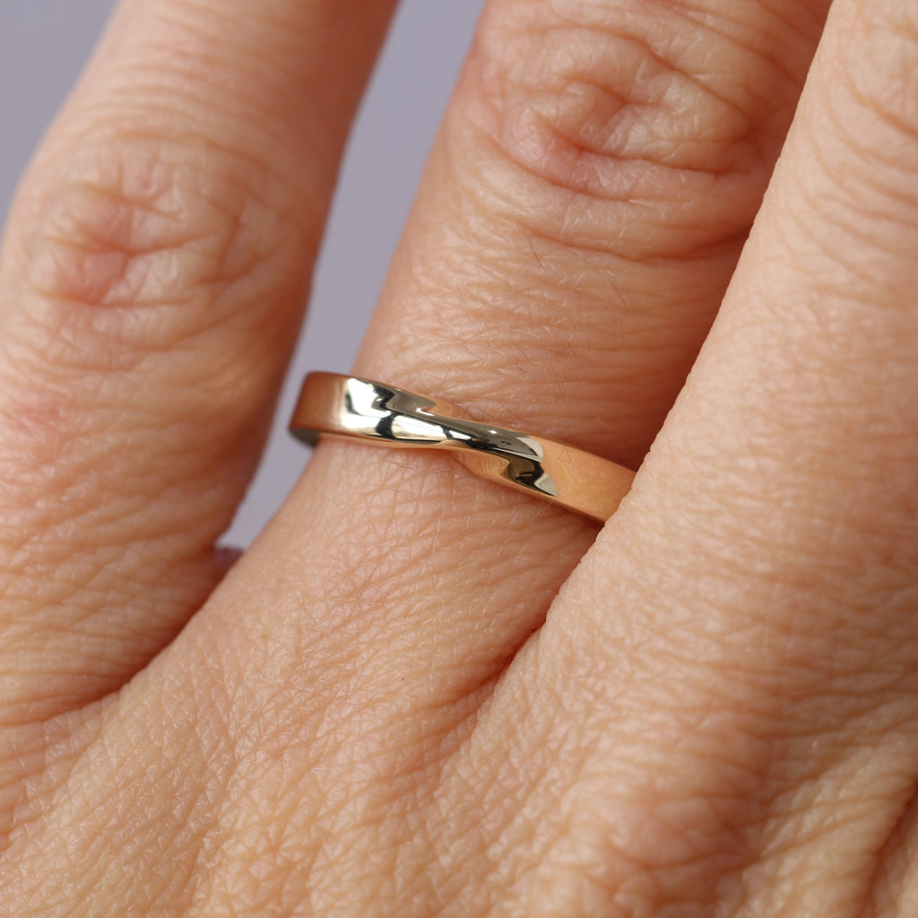 gold mobius twist wedding band on hand