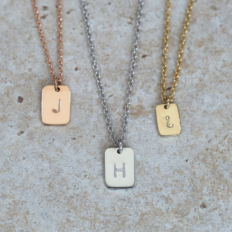 petite initial tablet necklace on neck