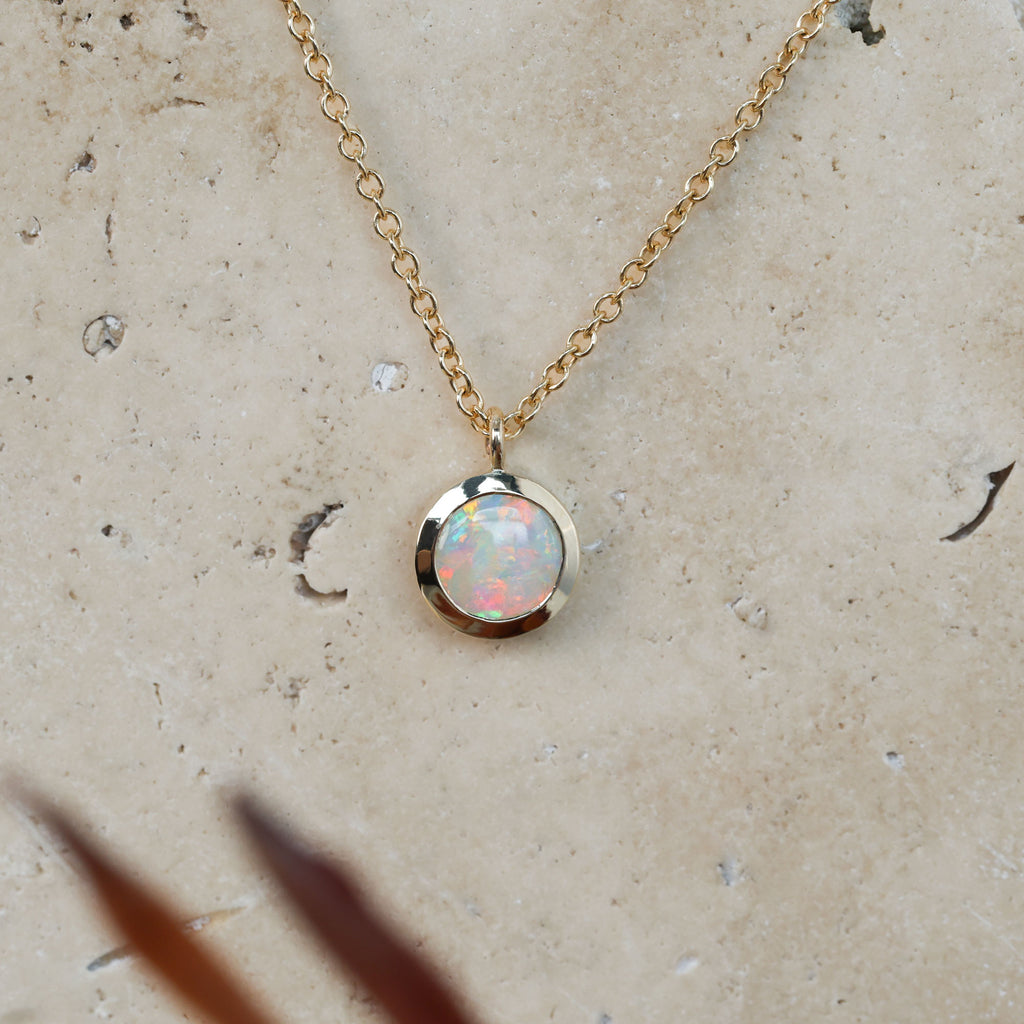 round cut opal set in a full 9ct yellow gold bezel east west setting