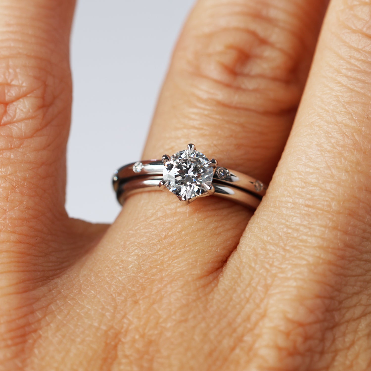 orbit diamond wedding band on hand with engagement ring