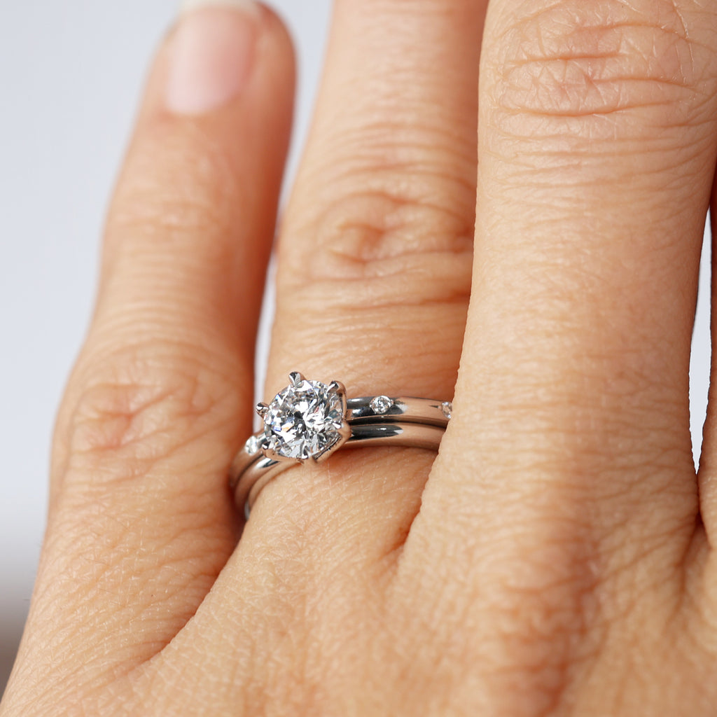 orbit diamond wedding band on hand with engagement ring