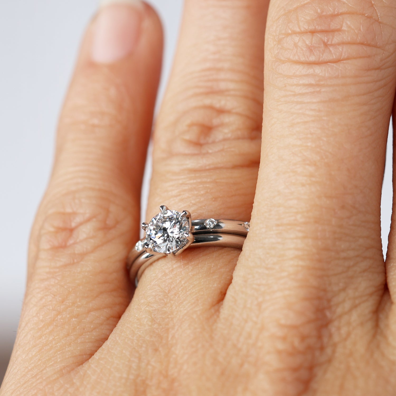 orbit diamond wedding band on hand with engagement ring