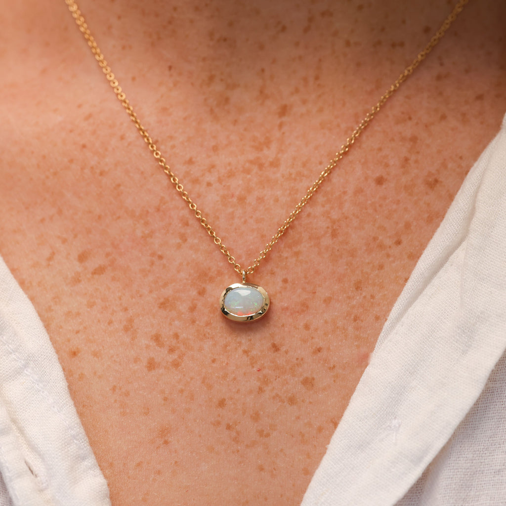 oval cut opal set in a full 9ct yellow gold bezel east west setting