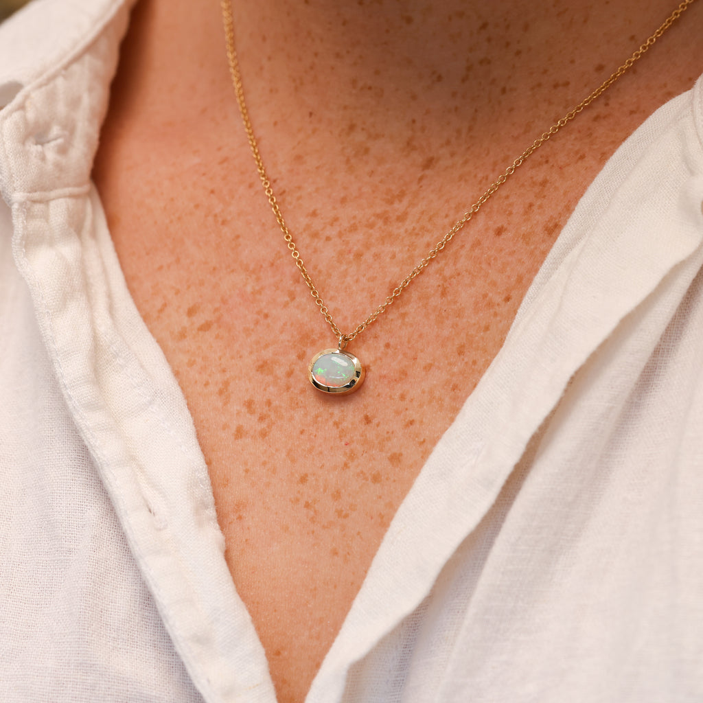 oval cut opal set in a full 9ct yellow gold bezel east west setting on necl