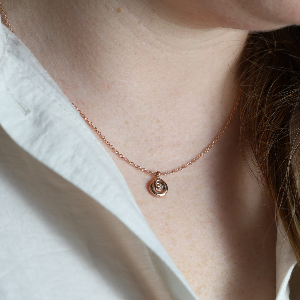 petite flux initial necklace on neck