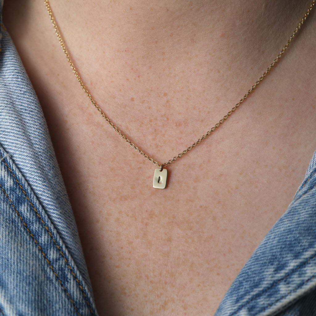 petite initial tablet necklace on neck