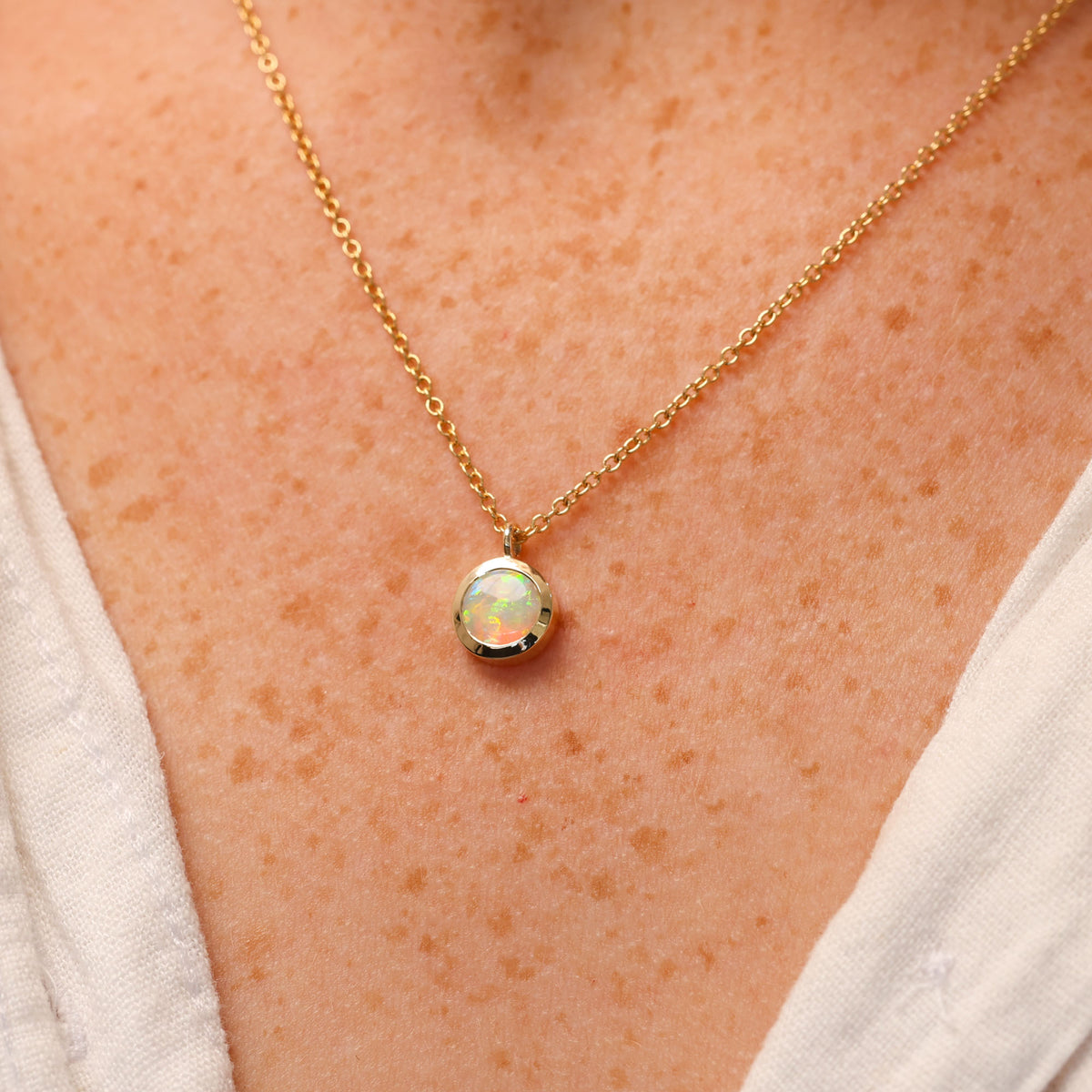 round cut opal set in a full 9ct yellow gold bezel east west setting