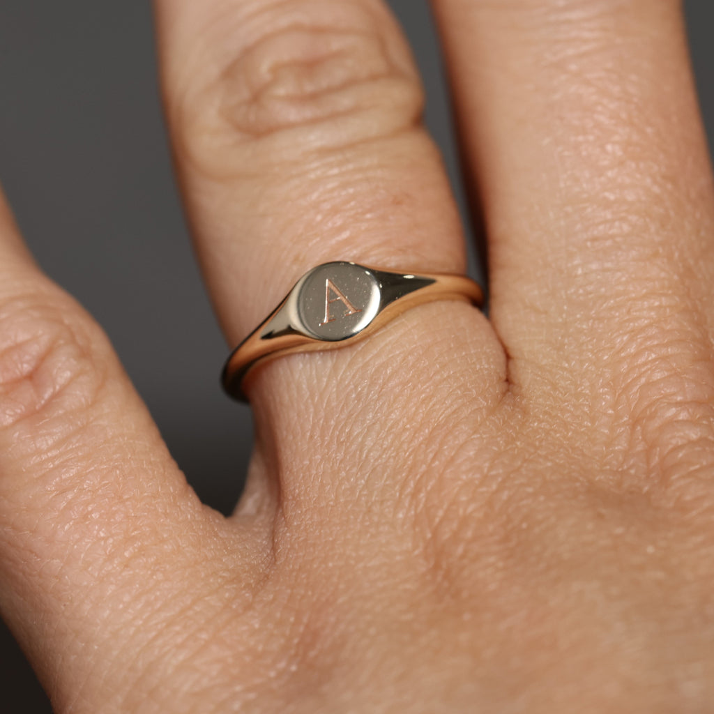 round letter signet ring on hand