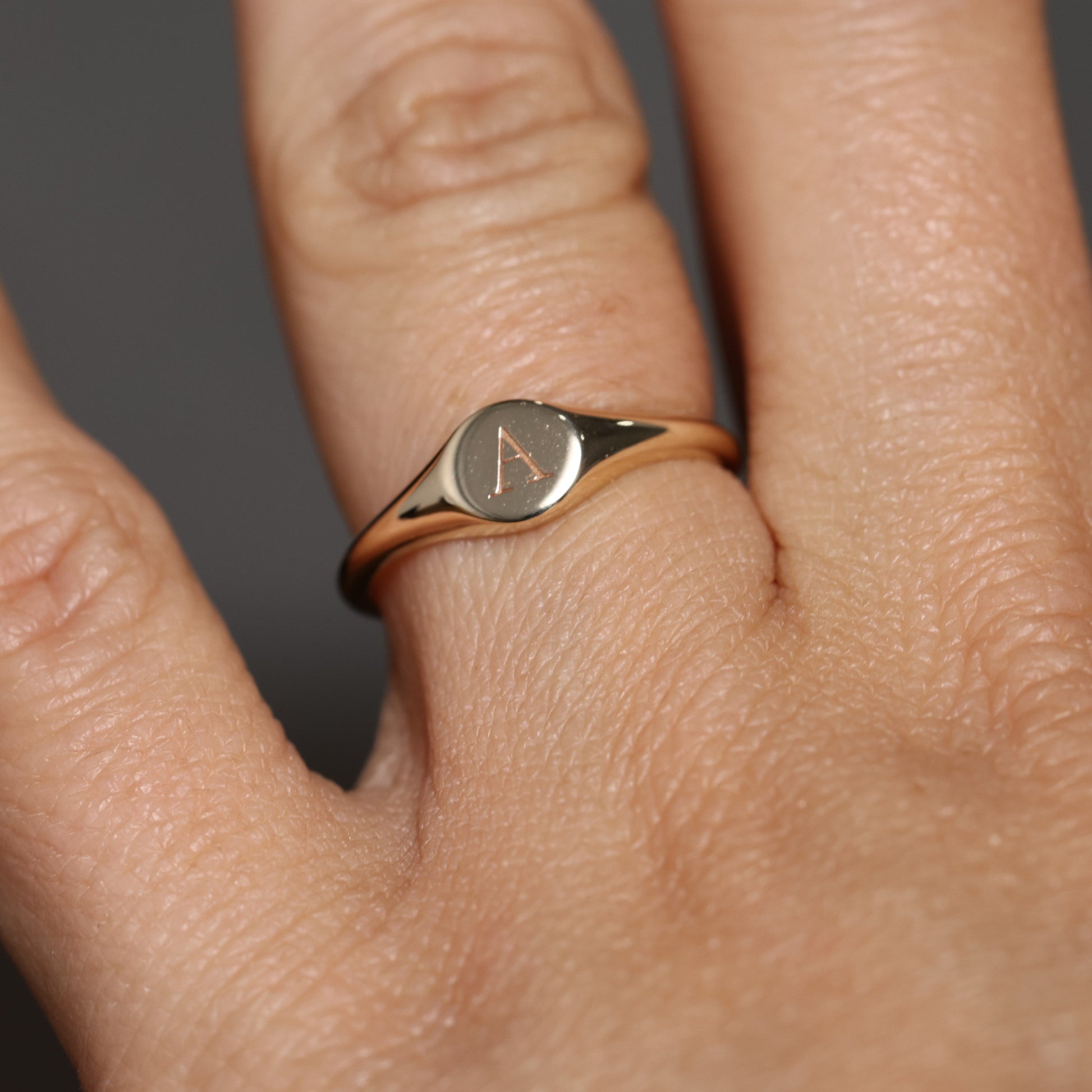 round letter signet ring on hand