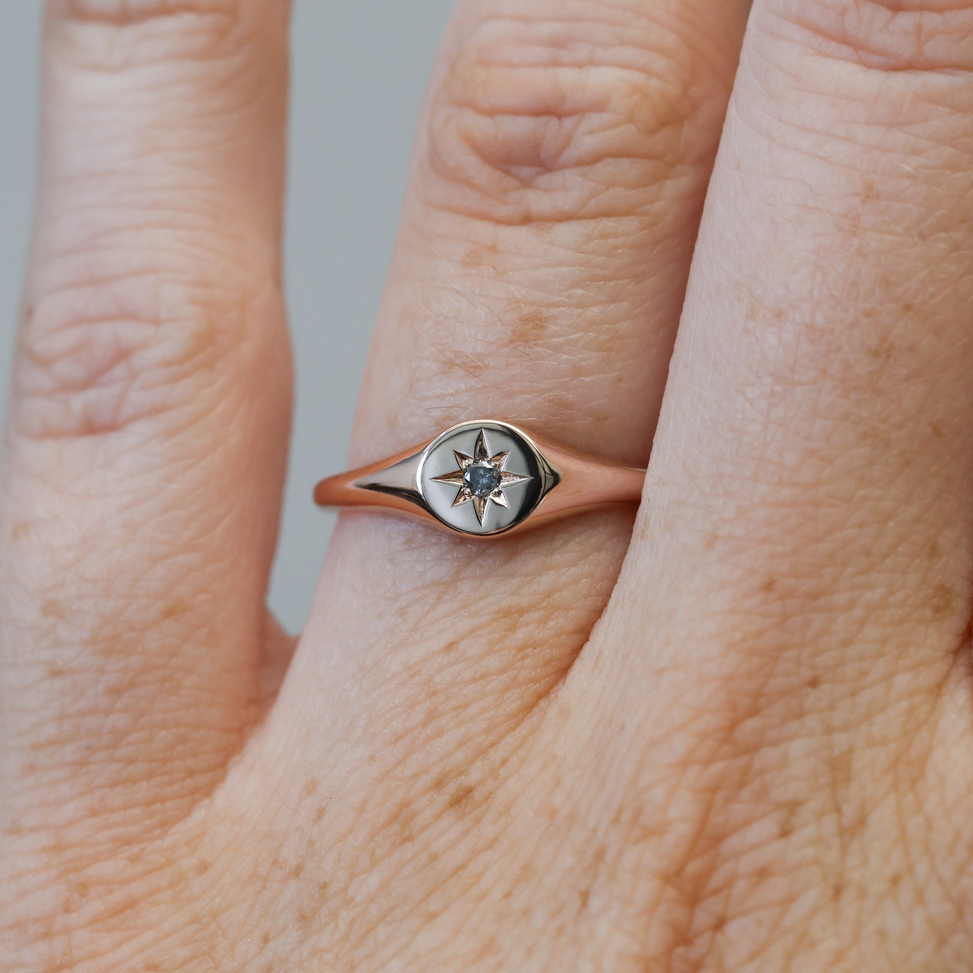 salt and pepper diamond signet ring on hand 