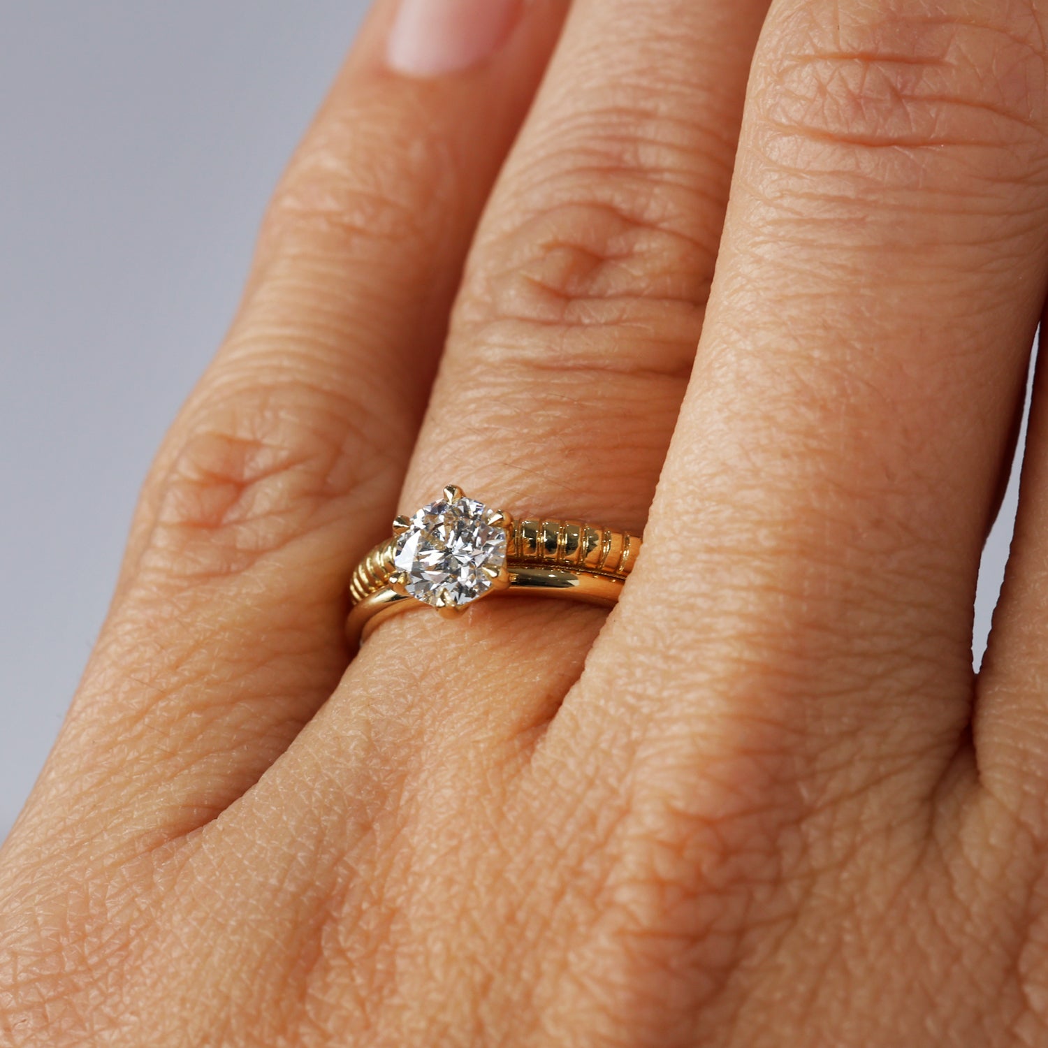 sol detailed wedding band on hand with engagement ring