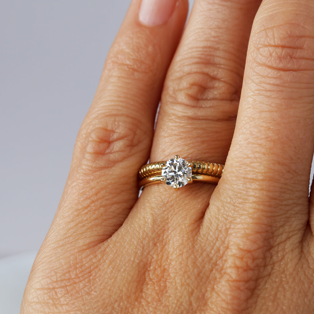 sol detailed wedding band on hand with engagement ring